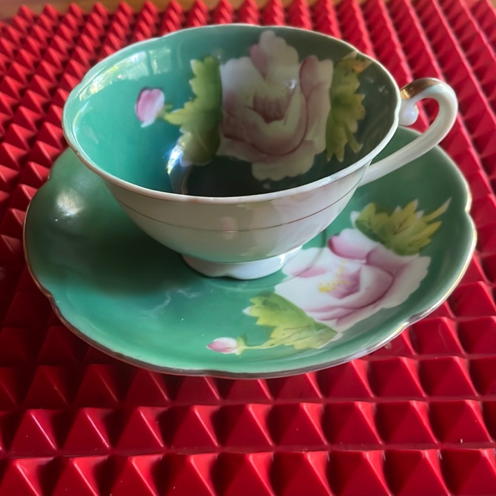 A PRETTY ANTIQUE ROSES IN GREEN TEACUP AND SAUCER